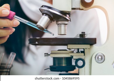 researchers Health care working in life science laboratory. Young female research scientist preparing and analyzing microscope slides in research lab