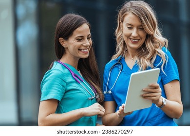 Researching news on a specific disease. Shot of two medical practitioners using a digital tablet together in a hospital. Healthcare staff having discussion in a hallway of private clinic. - Powered by Shutterstock