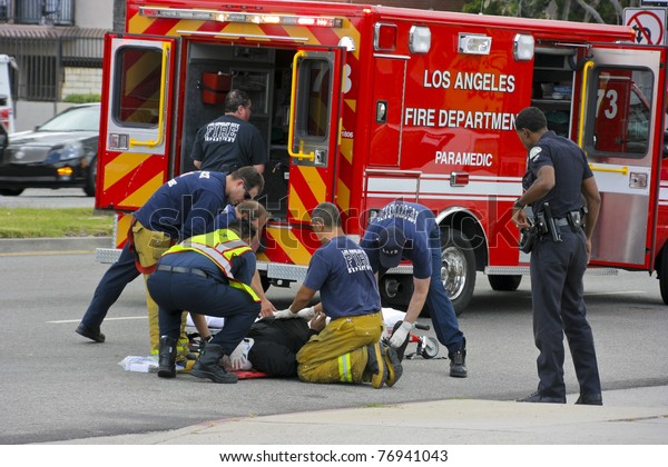 RESEDA, CALIFORNIA, USA - MAY 9: Firefighters\
help the victim of car accident on May 9, 2011 on Sherman Way in\
Reseda, California.