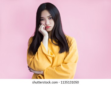 Resentment, Boredom, Pouting Lips. Boring, Dull Face. Offended Girl Looks With Sadness And Is Ready To Cry. Pink Background, Yellow Sweetshot, Standing Leaning On The Arm