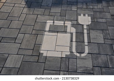 reservation of road signs for electric cars. Charging station with gas station symbol with cable and plug for charging the electric battery, sprayed on the parking lot tiles