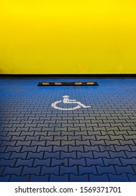 Reserved Blue Car Parking Space For Handicapped People. International Disabled Symbol Painted In A Shopping Center Parking Lot.