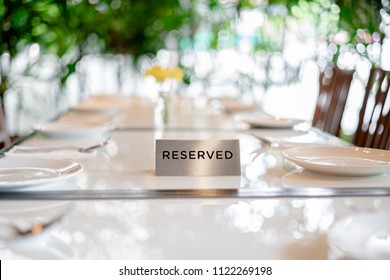 Reserved Metal Plate On The Table With Blurry Background. Reservation Seat At Restaurant.