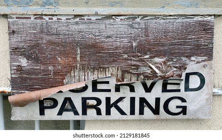 Reserved Parking sign in the process of peeling away