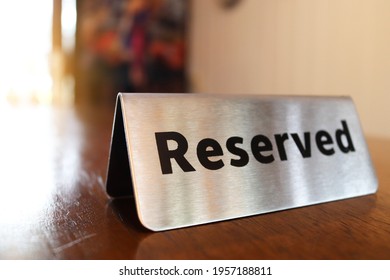 Reserved Sign On Top Of A Wooden Table In A Restaurant, Reservation Seat At Restaurant For Dating On Celebrate Day Concept(select Focus).