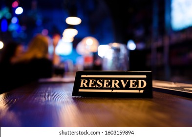 Reserved Sign Standing On Wooden Table In Bar. Pub Interior