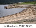 Reservoir with dead trees and rocks, Reservoir banks with low water level, low angle landscape of reservoir, environmental change  in summer,  Reservoir lake view, landscape 