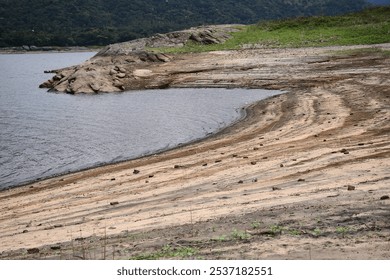 Reservoir with dead trees and rocks, Reservoir banks with low water level, low angle landscape of reservoir, environmental change  in summer,  Reservoir lake view, landscape 