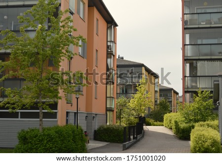 Residential apartment housing in the cosy neighbourhood called Tuomarila in Espoo, Finland. Modern Scandinavian architecture with different color buildings surrounded by trees and walking paths.