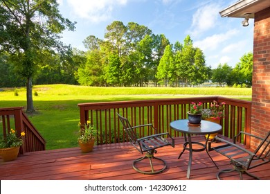 Residential backyard deck overlooking lawn and lake
