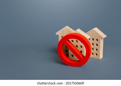Residential buildings and red prohibition symbol No. Restrictions ban on construction. Inaccessible expensive housing. Restriction building compaction. Underdeveloped infrastructure