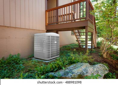 A Residential Central Air Conditioning And Heating Unit Sitting Outside A Home.
