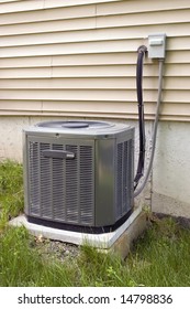 A Residential Central Air Conditioning Unit Sitting Outside A Home.