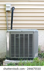 A Residential Central Air Conditioning Unit Sitting Outside A Home.