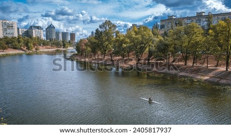 Residential district in Kyiv city, by the river channel of Dnieper. Kayak floating on river