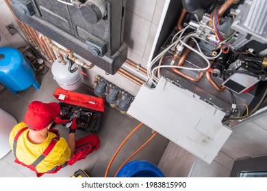 Residential Heating Systems Technician Performing Scheduled Maintenance On The Gas Heating System. 