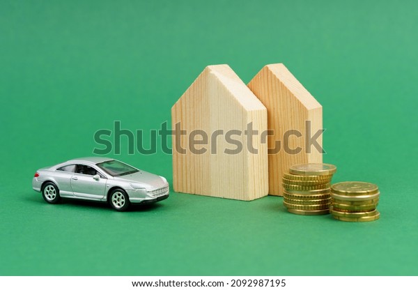 Residential house and car purchase\
concept: house mockup, toy car. Isolated on a green\
background.