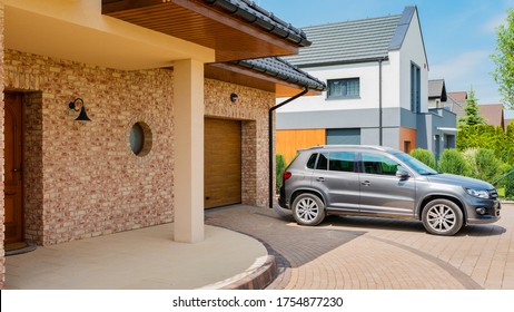 Wohnhaus mit silbernem Auto, auf der Einfahrt vor dem Haus geparkt. Familienhaus - perfektes Nachbarschaftskonzept