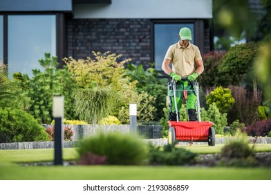 Residential Lawn Grass Fertilizing Using Push Spreader. Gardener Job Theme.