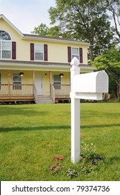 Residential Mailbox On Suburban Lawn Home In Background During Early Morning Light