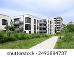 Residential Modern Buildings in Germany Munich with White Facade, Green Landscaping. Comfort Multifamily Low rise, High rise Block of Flats or Apartment Building. New Living Building Complex.