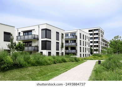 Residential Modern Buildings in Germany Munich with White Facade, Green Landscaping. Comfort Multifamily Low rise, High rise Block of Flats or Apartment Building. New Living Building Complex.