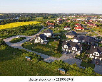 Residential neigborhood in sunset, bird eye view. Suburbs or village streets with luxury house buildings