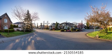 Residential neighborhood Street in Modern City Suburbs. Sunny Spring Morning Sunrise. Fraser Heights, Surrey, Greater Vancouver, British Columbia, Canada. Panorama