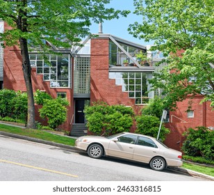 Residential townhouses on the street going uphill with a car parked in front - Powered by Shutterstock