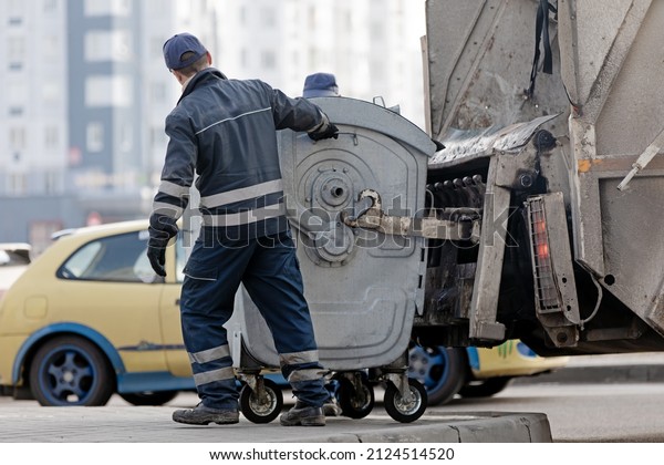 Residential Trash  Garbage\
Service. Workers of Municipal Recycling Garbage Collector during\
Emptying Bin
