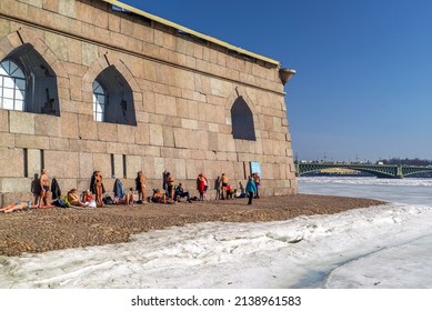 Residents Of St. Petersburg Sunbathe At The Walls Of The Peter And Paul Fortress In The Spring Near The Ice