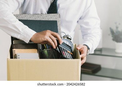 Resignation. businessman packing personal company belongings in a brown cardboard box when he deciding resignation and changing work in the future.