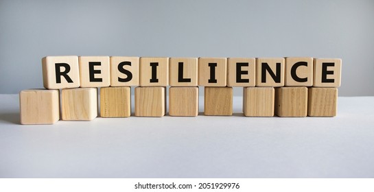 Resilience Symbol. Word 'Resilience' Written On Wooden Blocks. Copy Space. Beautiful White Table, White Background. Business And Resilience Concept.