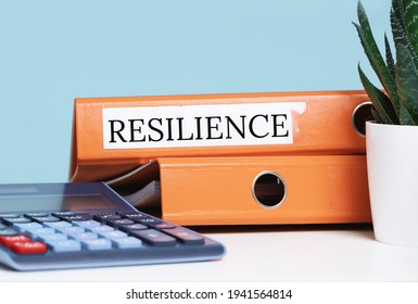 Resilience Word On Business Folder At Office Desk. Calculator. Recovering And Building Resilience Concept, Coping With Crisis. Copy Space