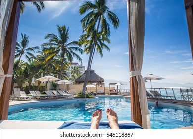 Resort Cabana Pool View With Woman's Feet View Perspective From Lying Down By Beach