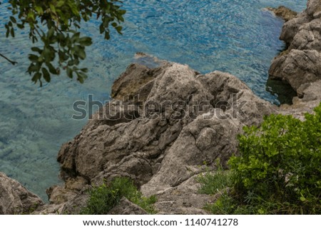 Resort environment concept of waterfront sea outdoor park district with stones and water surface and small waves in summer bright day time