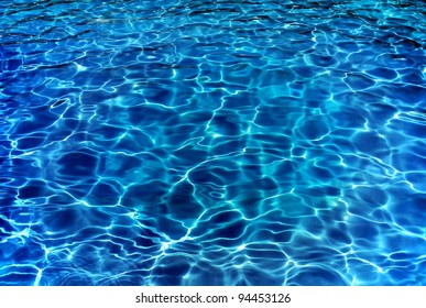 Resort pool water ripples in evening.