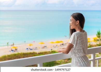 Resort vacation happy Asian woman tourist enjoying ocean view from beach front hotel room on Caribbean holidays.