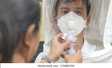Respirator Fit Test Prepared For COVID-19. Asia Man Testing Repiratory System With N-95 Surgical Mask To Checks Properly Fits Face To Wears.