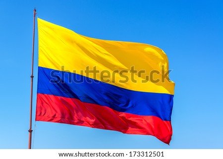 Resplendent Colombian flag waving in the wind set against a beautiful blue sky