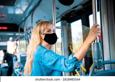 Responsible Woman With Black Fabric Cloth Sewn Mask On Face Travelling By Bus. Blonde Female Wearing Cloth Face Mask Standing In Public Transportation.