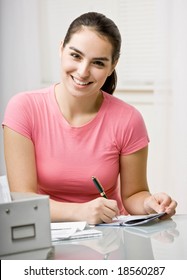 Responsible Woman Writing Checks In Checkbook To Pay Monthly Bills