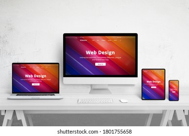 Responsive web site design on different devices. Web design studio desk with laptop, computer display, tablet and mobile phone