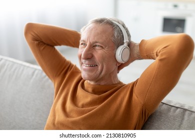 Rest And Relax Concept. Calm mature man sitting leaning back on couch, listening to music, audio book or podcast, enjoying meditation for sleep and peaceful mind in wireless headphones, closeup - Powered by Shutterstock