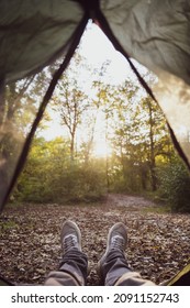 Rest in a tent in the forest. Human feet in a campsite, first person view