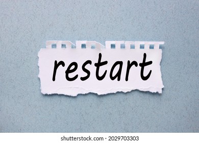 Restart. Text On Torn White Paper On Blue Background