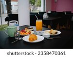 Restaurant breakfast, coffee, croissant, orange juice, toast, jam, fruits and chocolate cake