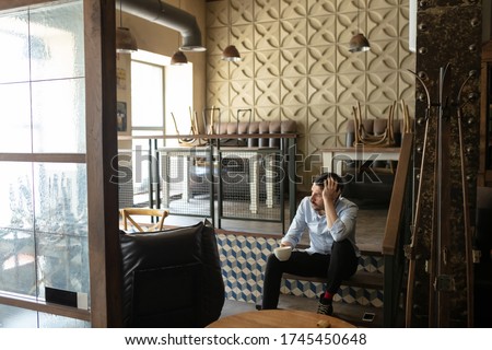 Restaurant, cafe, bar closed due to COVID-19 or Coronavirus outbreak lockdown, stressed owner of small business, depressed, despair. Businessman exhausted, upset. Business, economy, finance crisis.