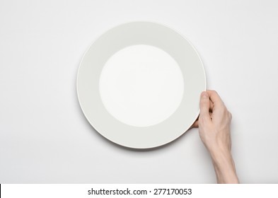 Restaurant And Food Theme: The Human Hand Show Gesture On An Empty White Plate On A White Background In Studio Isolated Top View