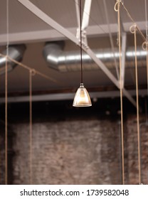 A Restaurant Interior In A Modern And Industrial Style. This Picture Details The Lighting Fixtures With A Hanging Light Bulb.